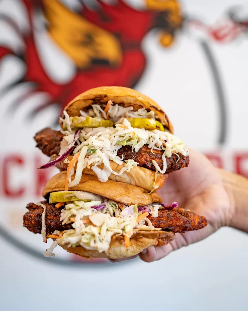 Two massive spicy chicken sandwiches with the Chicken Fire logo in the background.