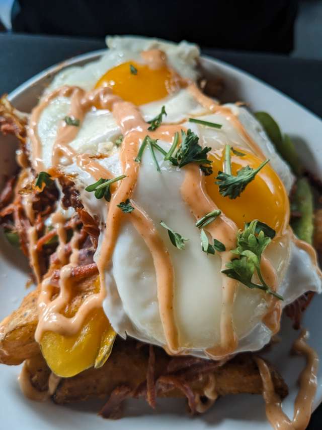 A large plate or corned beef hash with an egg on top.